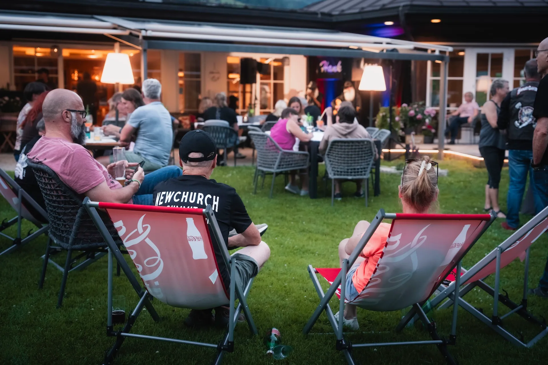 Gäste in Liegestühlen bei Livemusik am Abend